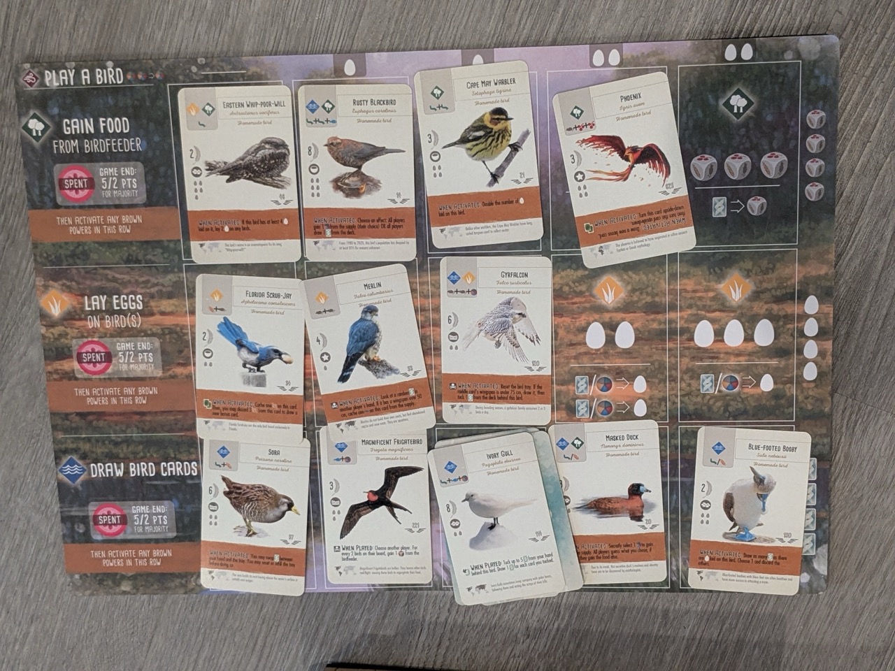 A top-down view of the Wingspan board with multiple custom cards placed on it.